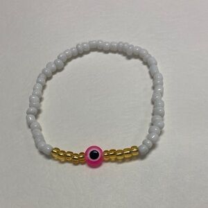Handmade White and Gold Beaded Bracelet with Pink Evil Eye Accent